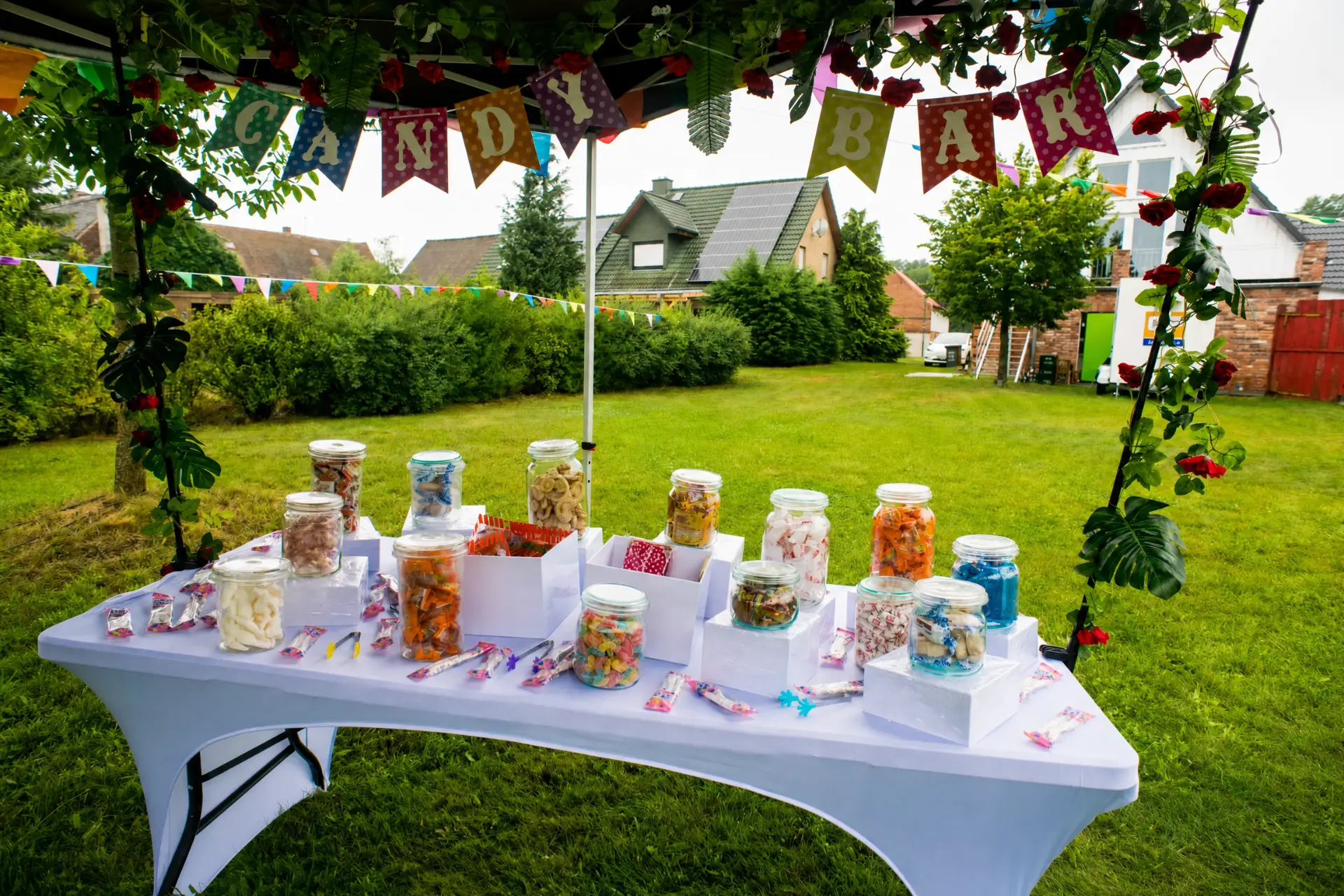 Candy Bar mit Rosen und Girlanden im Garten
