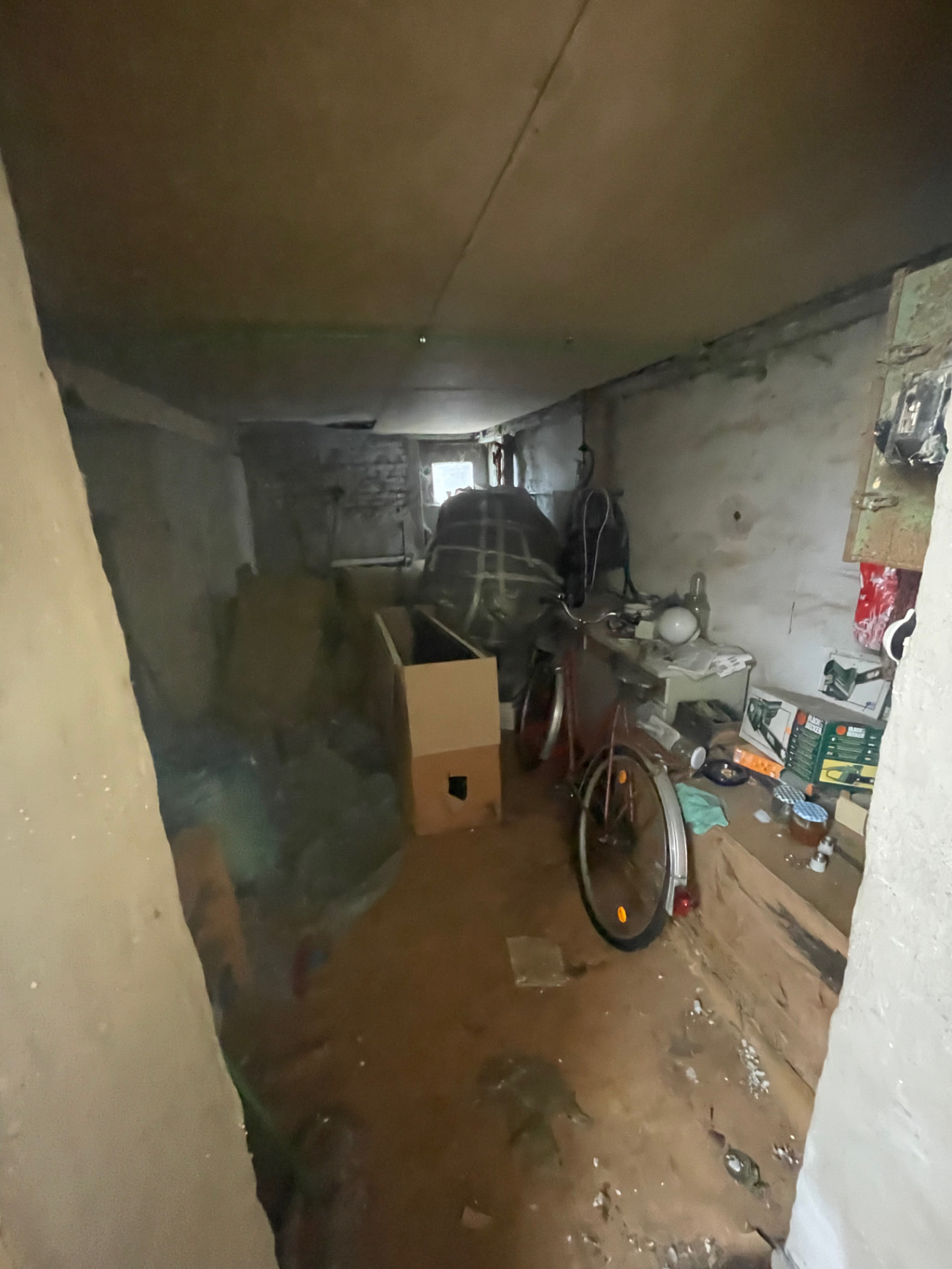 Das ehemalige Lager auf Friends vor dem Umbau: dunkler Raum mit rohen Wänden, altem Fahrrad und Gerümpel — heute der Eingang in den Club Kosmos