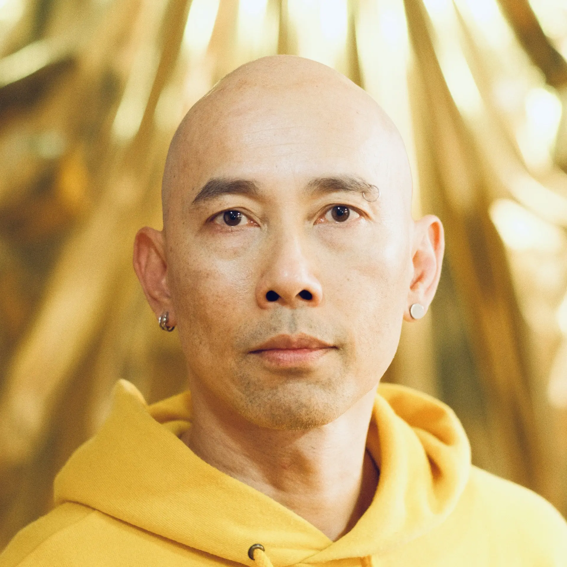 Porträt von Ming Poon, Künstler und Choreograf, vor goldenem Hintergrund