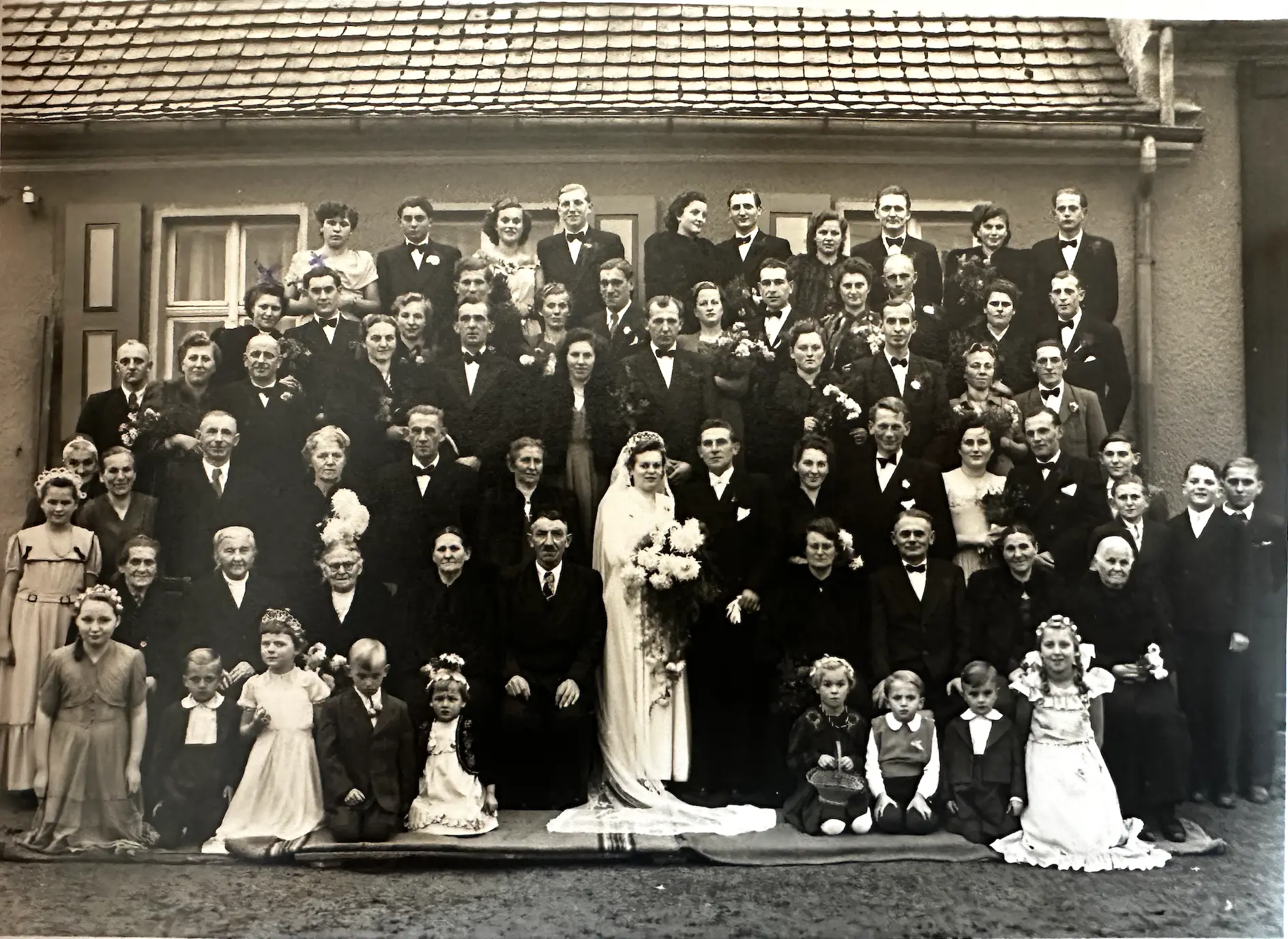 Historische Schwarzweiß-Aufnahme einer großen Hochzeitsgesellschaft vor dem Gasthof in Bräsen