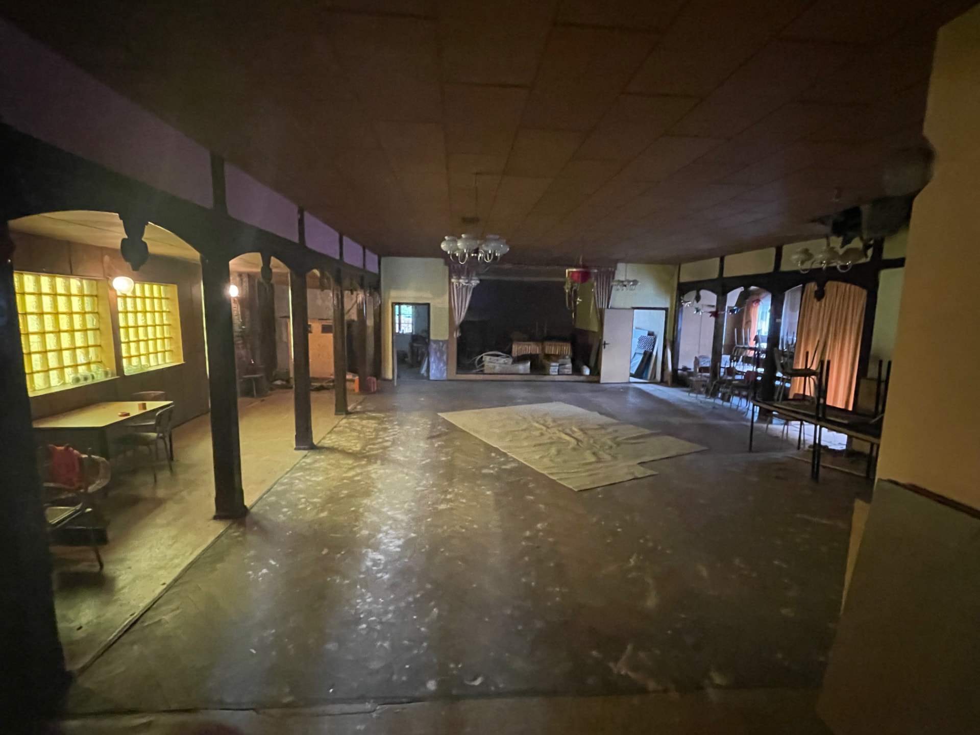 Blick in den alten Theatersaal auf Friends vor dem Umbau: marode Kassettendecke, dunkle Holzstützen, alte Kronleuchter und rechts vorne das durchgefaulte Dach
