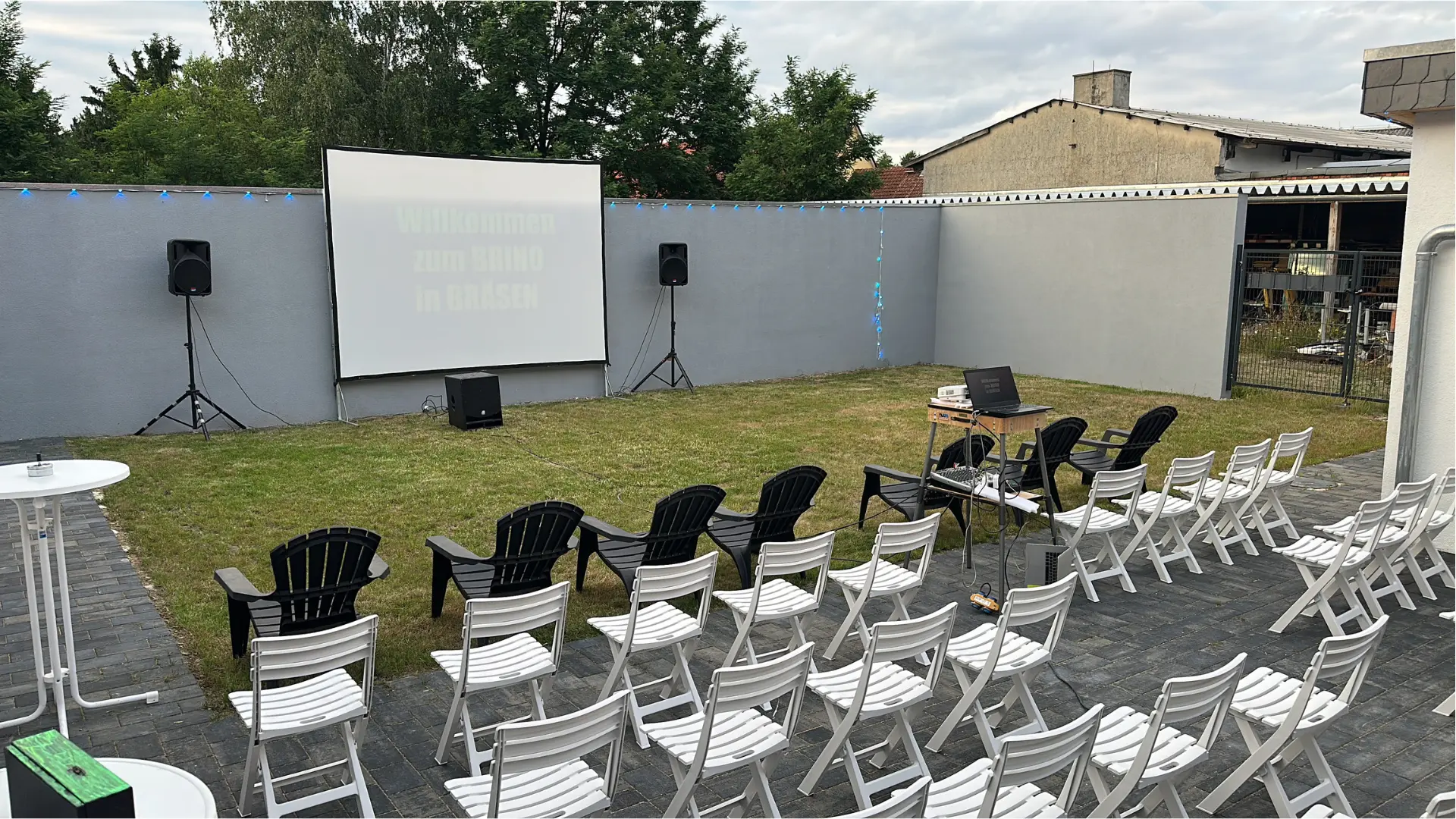 Sommerkino BRINO im Innenhof: Leinwand, Boxen und Stuhlreihen im Freien