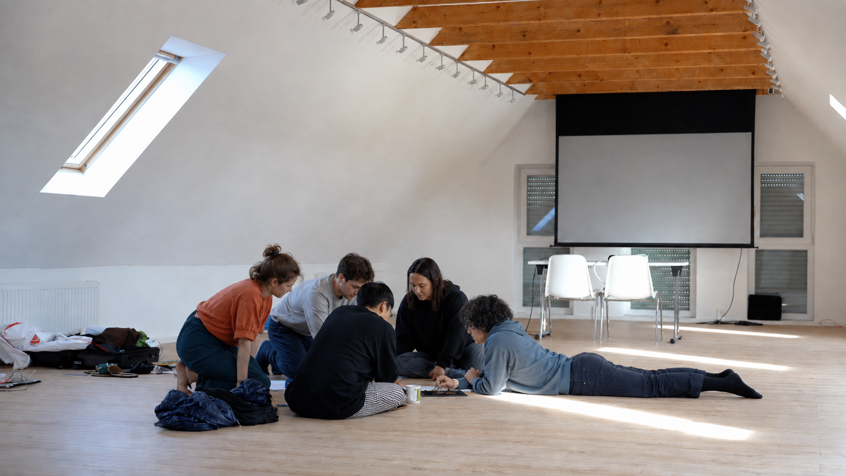 Gruppe arbeitet gemeinsam auf dem Boden des lichten Seminarraums